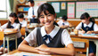 © SpeedShutter - Smiling Japanese girl sitting at a desk in the school classroom.Elementary or Primary school age.