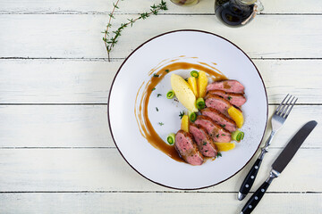 Wall Mural - Roast duck fillet with mashed potato and orange sauce on wooden background