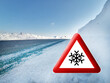 Straße im Winter - Warnschild mit Schnee und Eis