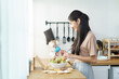© DG PhotoStock - Woman enjoy preparing salad in a wooden bowl.