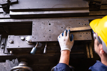 Professional white ethnicity mechanical engineer inspecting and measuring the metal gear, engineer or repair man examine and fix machine in factory.