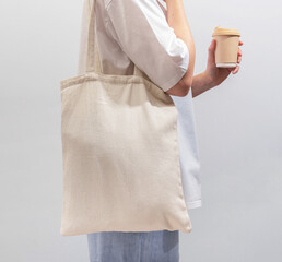 Poster - Carrying textile shopper, eco tote bag, drinking from takeaway coffee cup