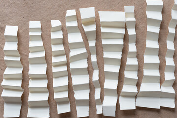 Poster - ripped paper strips with fan folds arranged vertically (more or less) on plain brown paper