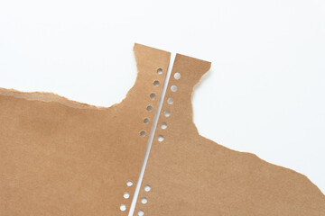 Sticker - torn brown cardboard with round binding holes on white