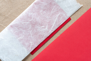 Sticker - tissue and solid red paper pieces on plain brown paper