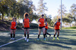 © Mat Hayward - Group of five female soccer players on a team warming up and running calisthenics during practice exercise for the sport.