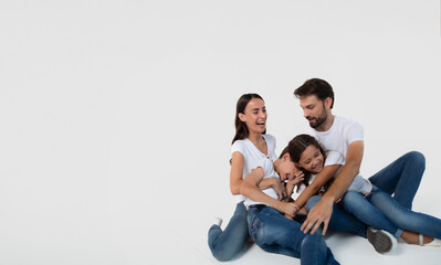 Wall Mural - Happy excited beautiful and smiling dad, mommy and them kids sitting on the floor isolated on white background