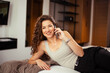 © Daniel - Beautiful woman with mobile phone enjoying in the hotel bed