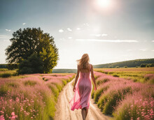 A Woman In A Pink Dress Walking Down A Dirt Path In A Summer Meadow