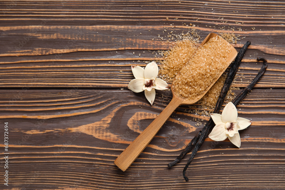 Spoon with aromatic vanilla sugar, flowers and sticks on wooden background
