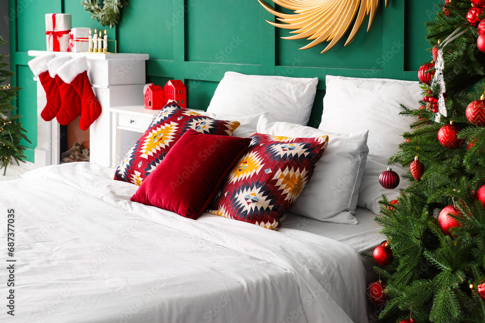 Big bed with beautiful pillows in bedroom decorated for Christmas