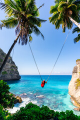 Wall Mural - Young woman tourist on Bali swing at Diamond beach at Nusa Penida island Bali, Indonesia