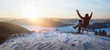 happy man traveler blogger work remote on laptop while enjoying winter nature landscape at sunset.  freedom, travel and remote work concept. banner with copy space.