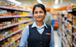 Cute hindu sales girl standing in a grocery store. Beautiful indian lady standing in a grocery store.