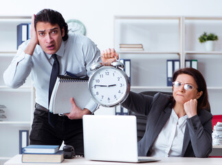 Wall Mural - Old female boss and young male employee in the office