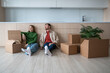 © DimaBerlin - Happy new homeowners tenants renters tired young couple man woman sitting on floor among cardboard boxes on kitchen. Moving to new flat apartment. Relocation, family mortgage concept.