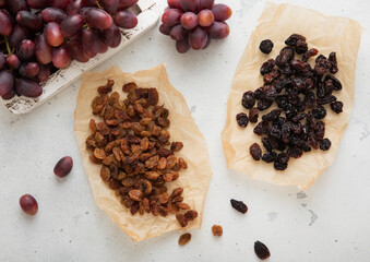 Wall Mural - Brown and dark sweet raisins with ripe red grapes on light background.Macro.