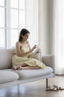 © fizkes - Pretty woman in dress resting on comfortable couch with digital tablet, web surfing internet, buy goods, clothes use electronic commercial retail websites, enjoy e-shopping at home. Marketplace apps