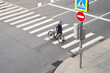 © nuclear_lily - Man crosses the road at a pedestrian crossing and carries a bicycle next to him. View from above.