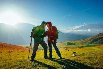 Canvas Print - Happy couple of tourists in mountain valley on a sunny day