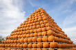 Beautiful decoration of pumpkins, a pyramid decorated with pumpkins, blue sky with clouds