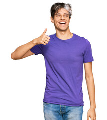 Sticker - Young hispanic man wearing casual clothes smiling happy and positive, thumb up doing excellent and approval sign