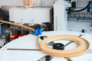 Poster - Machine tools for gluing edging onto furniture wood board, Edging PVC. Photo of cutter machine, close-up, coil with melamine edge