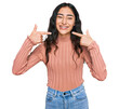 © Krakenimages.com - Hispanic teenager girl with dental braces wearing casual clothes smiling cheerful showing and pointing with fingers teeth and mouth. dental health concept.