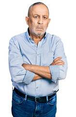 Canvas Print - Senior man with grey hair and beard with arms crossed gesture relaxed with serious expression on face. simple and natural looking at the camera.