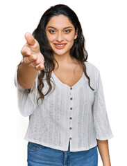 Wall Mural - Brunette young woman wearing casual clothes smiling friendly offering handshake as greeting and welcoming. successful business.