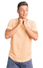Wall Mural - Young handsome man wearing casual clothes laughing nervous and excited with hands on chin looking to the side