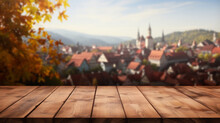 Empty Wooden Table Top With Scandinavia Village Or Traditional European Town/city Background And Autumn Leaves. Autumn Themed. Bokeh Style Background. Stage For Product Design. Generative AI
