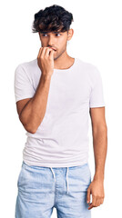 Sticker - Young hispanic man wearing casual clothes looking stressed and nervous with hands on mouth biting nails. anxiety problem.