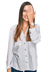 Canvas Print - Young beautiful woman wearing casual clothes covering one eye with hand, confident smile on face and surprise emotion.