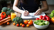 Person writing in a notebook surrounded by a variety of colorful fruits and vegetables, planning healthy diet.