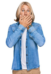 Wall Mural - Caucasian man with blond long hair wearing casual denim jacket shocked covering mouth with hands for mistake. secret concept.