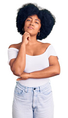 Wall Mural - Young african american girl wearing casual clothes serious face thinking about question with hand on chin, thoughtful about confusing idea