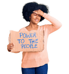 Wall Mural - Young african american girl holding power to the people banner stressed and frustrated with hand on head, surprised and angry face