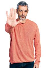 Poster - Middle age hispanic with grey hair wearing casual sweater doing stop sing with palm of the hand. warning expression with negative and serious gesture on the face.