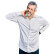 © Krakenimages.com - Middle age hispanic with grey hair wearing casual white shirt suffering of neck ache injury, touching neck with hand, muscular pain