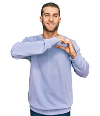 Poster - Young caucasian man wearing casual clothes smiling in love doing heart symbol shape with hands. romantic concept.