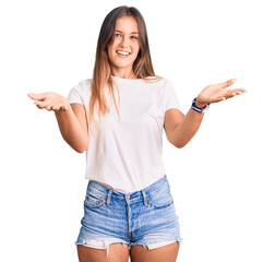 Beautiful caucasian woman wearing casual white tshirt smiling cheerful offering hands giving assistance and acceptance.