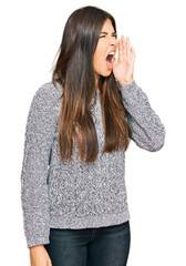 Canvas Print - Young brunette woman wearing casual winter sweater shouting and screaming loud to side with hand on mouth. communication concept.