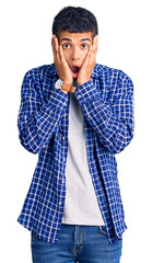 Poster - Young african amercian man wearing casual clothes afraid and shocked, surprise and amazed expression with hands on face