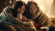 © redflower - Two young women wrapped in a warm blanket, enjoying hot drinks in a cozy atmosphere