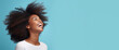 Portrait of young happy black woman with Ultimate Afro hairstyle. Skin care beauty, skincare cosmetics. Isolated over blue background.