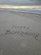 Happy Birthday als Schrift im Strandsand