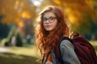 © Ева Поликарпова - A woman with red hair is seen wearing glasses and carrying a backpack. This image can be used to depict a traveler, a student, or a professional on the go.