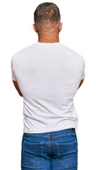 Wall Mural - Handsome muscle man wearing casual white tshirt standing backwards looking away with crossed arms