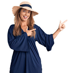 Canvas Print - Middle age hispanic woman wearing summer hat smiling and looking at the camera pointing with two hands and fingers to the side.